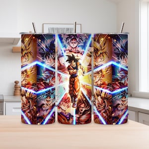 Puede incluir: Un vaso cilíndrico de acero inoxidable con un estampado gráfico vibrante de varias transformaciones de personajes de anime en tonos azules, amarillos y naranjas, que incluye una pajita de metal insertada en la tapa.
