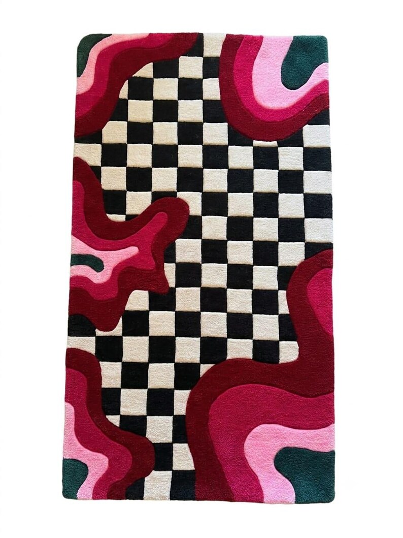 May include: A rectangular tufted rug featuring a central black and white checkered pattern flanked by organic, wavy shapes in shades of deep red, magenta, light pink, and dark forest green, creating a high-contrast, multi-colored floor covering.