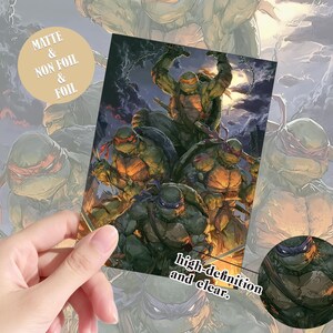 May include: A rectangular print featuring the four Teenage Mutant Ninja Turtles in a dynamic action pose against a dark, stormy sky. A circular inset shows a close-up of the turtle wearing a purple mask. Text reads MATTE & NON FOIL & FOIL.