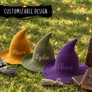 May include: Three pointed hats in mustard yellow, olive green, and purple, each featuring a wide brim and a custom name embroidered in cursive script: Maeve, Lydia, and Elena. The text CUSTOMIZABLE DESIGN is displayed at the top of the image.