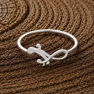 Anillo con símbolo de madre e hijo, minimalista y ajustable en plata, joyería que simboliza el amor entre madre e hijo.