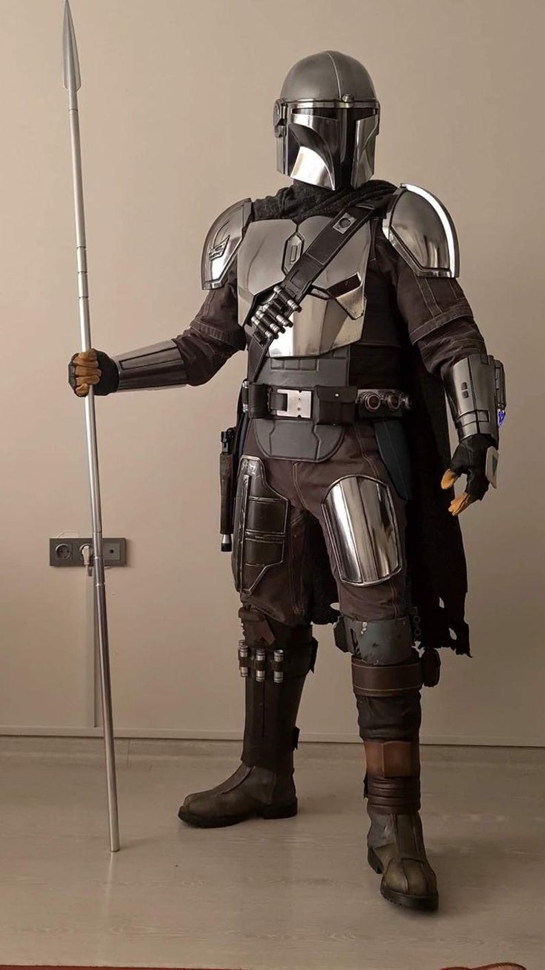 Puede incluir: Un traje de armadura completo en color plata y gris oscuro que incluye un casco met&aacute;lico con visor en forma de T, hombreras, peto, guanteletes y placas para las piernas. El conjunto cuenta con una capa oscura y una lanza larga y delgada.