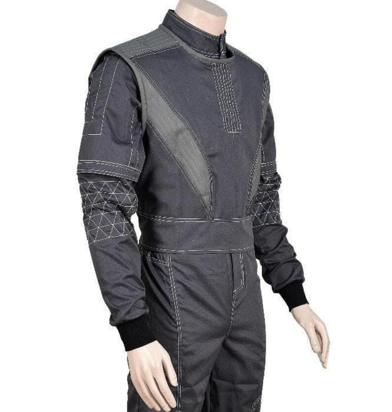 May include: A dark gray racing suit featuring a high collar, long sleeves with black ribbed cuffs, and white contrast stitching. The torso includes diagonal panels and a wide waistband, while the sleeves display a geometric triangular pattern.