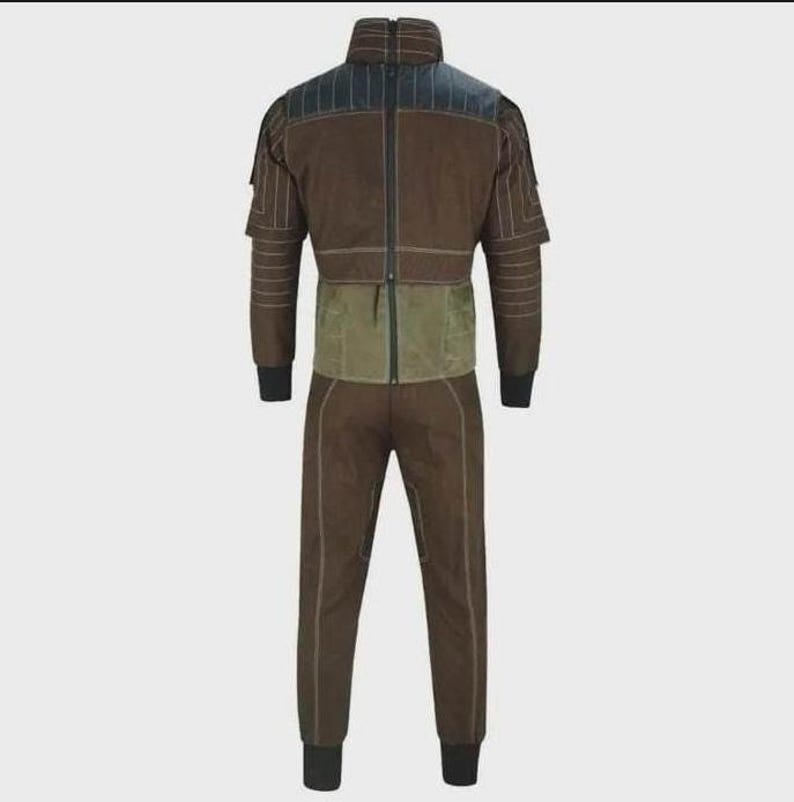 Puede incluir: Un mono de color marr&oacute;n y verde oliva con cuello alto, cremallera frontal completa y mangas largas con pu&ntilde;os negros acanalados. La prenda incluye paneles estructurados en los hombros con costuras horizontales y pantalones a juego con costuras.