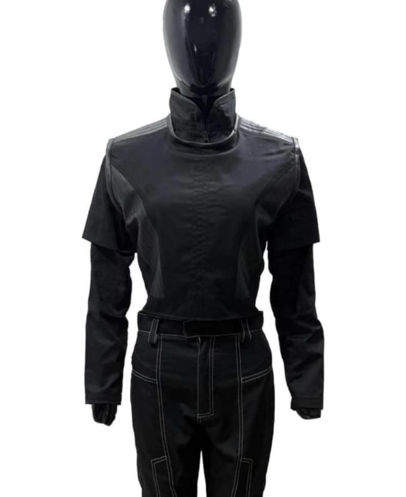 May include: A black long-sleeved top with a high collar and a structured bodice featuring layered shoulder panels, paired with matching black trousers that have prominent white contrast stitching along the legs and a belt loop waistband.