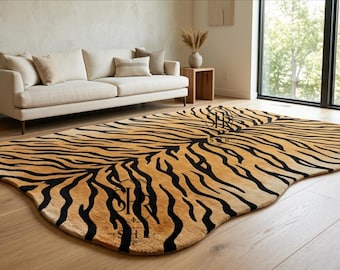 Puede incluir: Una alfombra con una forma orgánica irregular que presenta un fondo beige y un patrón de rayas de tigre negras. La alfombra muestra dos logotipos negros con las letras SHR y SHU impresas en la superficie. La alfombra está sobre un suelo de madera clara.