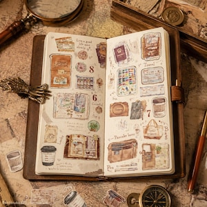 Pode incluir: Um diário aberto com ilustrações em aguarela de artigos de viagem, incluindo chávenas de café, sacos e artigos de papelaria. As páginas contêm texto escrito à mão como Live a good life meet slowly, Travel e Pancake buns, além de esboços.