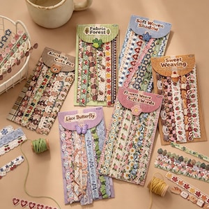 Pode incluir: V&aacute;rios cart&otilde;es retangulares de papel&atilde;o exibem fitas decorativas de renda e tecido com padr&otilde;es de flores, borboletas, animais e comida. Cada cart&atilde;o apresenta um r&oacute;tulo tem&aacute;tico como Fabric Forest, Knitting Cute Pet, Lace Butterfly, Soft Woven Shadow, Sweet Weaving e Flowers Weave Soft & Words, juntamente com pequenos enfeites correspondentes.