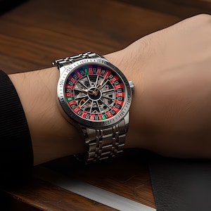 Op de afbeelding: Een zilverkleurig polshorloge met een roulettewielontwerp op de wijzerplaat met rode, groene en zwarte segmenten. Het horloge heeft een metalen schakelarmband en een ronde kast met een zilveren rand, met een complex intern mechanisme.