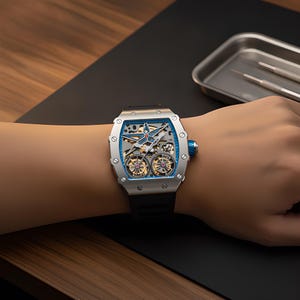 May include: A silver-toned tonneau-shaped wristwatch featuring a skeletonized dial with a prominent blue star-shaped bridge, dual balance wheels, and a black rubber strap. The case is secured with visible screws and includes a blue crown.