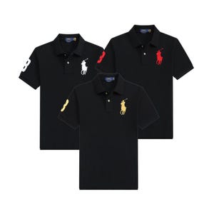 Peut inclure: Trois polos noirs à manches courtes avec col et patte de boutonnage. Chaque polo présente un logo Polo Ralph Lauren sur la poitrine et un grand chiffre sur la manche, avec des broderies respectivement en blanc, rouge et jaune.