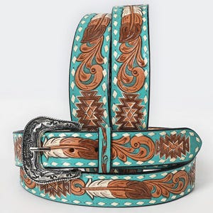 May include: A turquoise leather belt featuring intricate brown embossed feather and geometric patterns. The belt includes a silver-toned metal buckle with ornate engraved detailing and a series of small white diamond-shaped accents along the edges.