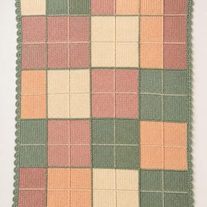 Pu&ograve; includere: Una coperta rettangolare all'uncinetto con una griglia di quadrati in tonalit&agrave; tenui di verde salvia, rosa antico, crema e pesca. Ogni grande quadrato &egrave; diviso in quattro quadranti da linee sottili e il bordo &egrave; rifinito a festoni.