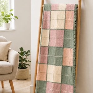 Pu&ograve; includere: Una coperta rettangolare all'uncinetto con un motivo a griglia di quadrati alternati in verde salvia, rosa tenue e crema. La coperta &egrave; realizzata con un punto testurizzato e rifinita con un bordo smerlato in filato verde salvia.