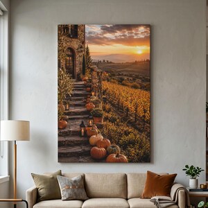 May include: A vertical wall art print depicting a stone staircase lined with orange pumpkins and lit lanterns, leading to a rustic building overlooking a vineyard at sunset with golden light illuminating the rolling hills in the background.