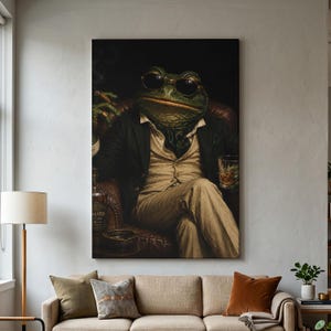 May include: A vertical wall art print depicting a green toad wearing a black blazer, a beige vest, and dark sunglasses. The toad sits in a leather chair, holding a lit cigar in one hand and a glass of amber liquid in the other, against a dark background.
