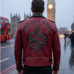 Peut inclure: Une veste en cuir rouge foncé ornée de clous métalliques argentés sur le col, les épaules et les poignets. Le dos présente une illustration peinte d'un serpent enroulé avec le texte "LONDON SOUL" inscrit en arc au-dessus en police gothique.