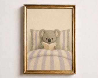May include: A framed wall art print featuring a grey koala sitting up in bed, reading an open book. The koala is positioned against a pillow with light blue and white vertical stripes, matching the striped bedding in a soft, muted colour palette.