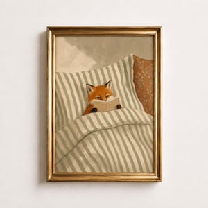 Könnte beinhalten: Ein gerahmter Kunstdruck, der einen orangefarbenen Fuchs zeigt, der in einem Bett unter einer weiß-grau gestreiften Decke liegt und ein offenes Buch liest. Der Fuchs liegt vor einem gestreiften Kissen, rechts ist ein einfarbig orangefarbenes Kissen.