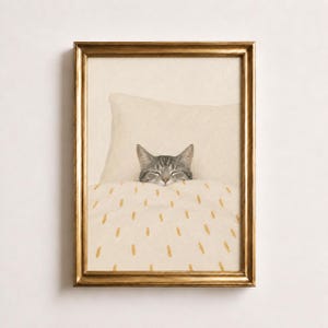 Könnte beinhalten: Ein gerahmter Kunstdruck, der eine graue getigerte Katze mit geschlossenen Augen zeigt, die in einem Bett ruht. Die Katze liegt unter einer cremefarbenen Decke mit kleinen gelben Strichmustern und ruht ihren Kopf auf einem passenden Kissen.