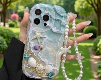 以下が含まれることがあります： 樹脂製の波模様が施されたスマホケースで、貝殻、ヒトデ、小さな白いパールが埋め込まれています。透明なビーズ、蝶の形のアクセント、白いリボンチャームが付いた長いビーズのリストストラップが付属しています。