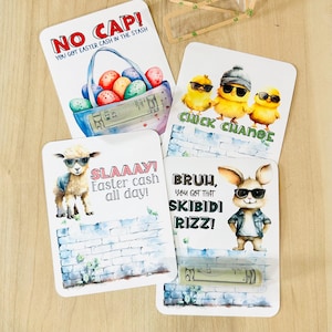 Könnte beinhalten: Vier Osterkarten mit Geld drin. Die Karten zeigen einen Korb mit Ostereiern, drei Küken, ein Lamm und einen Hasen. Jede Karte hat einen lustigen Spruch drauf. Die Karten sind perfekt zum Verschenken oder um Ihren Osterfeiern etwas Spaß zu verleihen.