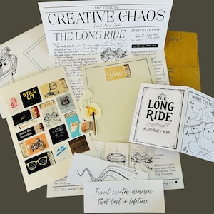 Puede incluir: Una colecci&oacute;n de art&iacute;culos de papeler&iacute;a que incluye un bolet&iacute;n Creative Chaos, un mapa de viaje Long Ride, una hoja de pegatinas con cajas de cerillas e iconos de viaje, una postal con una ilustraci&oacute;n de c&aacute;mara y una tarjeta con el texto Travel creates memories.