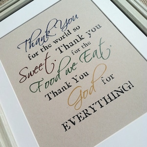 May include: A framed print with a beige background and black text that reads "Thank you for the world so sweet. Thank you for the food we eat. Thank you God for everything!"