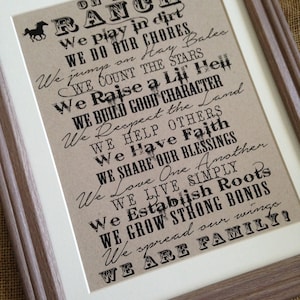 May include: A framed print with a rustic brown background and black text that reads "On the Ranch" and lists a series of values and activities associated with ranch life. The text includes phrases like "We play in dirt", "We do our chores", "We count the stars", and "We are family!"