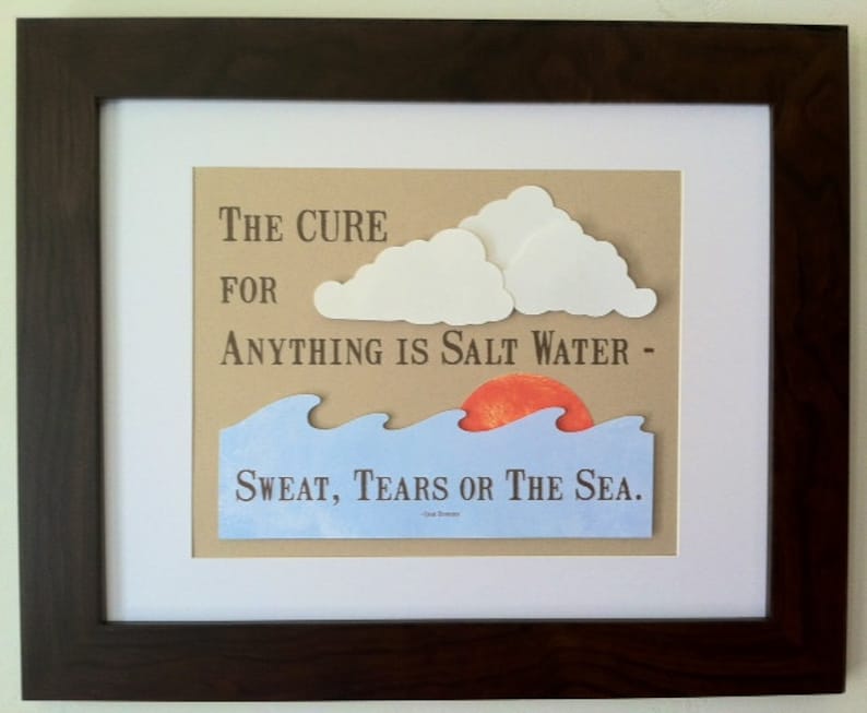 May include: A framed print with a brown background and white paper mat. The print features a quote: "The cure for anything is salt water - sweat, tears or the sea."