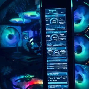Puede incluir: El interior de una caja de ordenador personalizada con una pantalla LCD vertical que muestra diagnósticos del sistema en tiempo real, incluyendo CPU, GPU, RAM y almacenamiento. Iluminado por ventiladores RGB multicolores.