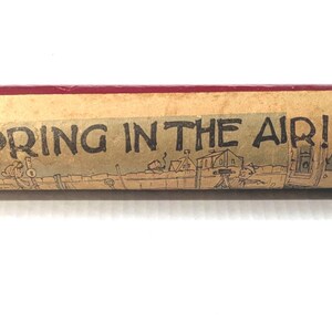 vintage 1940s kaleidoscope, features "spring is in the air" cartoon, made of paper, cardboard, and glass