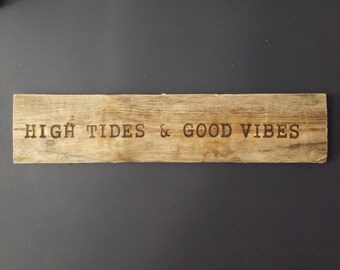 May include: A rustic wooden sign with the text "HIGH TIDES & GOOD VIBES" burned into the surface.