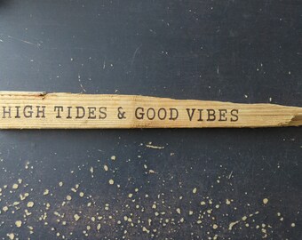 May include: A wooden sign with the text "HIGH TIDES & GOOD VIBES" burned into the surface.