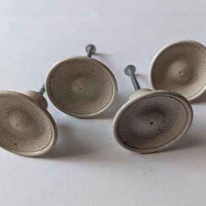 Vintage plastset med fyra vita lådhandtag, knoppar och beslag från 1950-talet