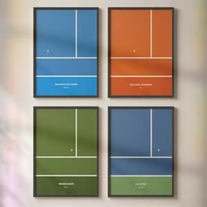 May include: Four framed rectangular wall art prints featuring minimalist tennis court diagrams. The prints are labeled Australian Open, Roland-Garros, Wimbledon, and US Open, with each displaying a unique color scheme and white court lines.