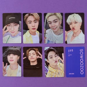 May include: A collection of seven rectangular photo cards featuring individual portraits of seven young people, plus one solid purple card with the text SOWOOZOO and JUNG KOOK printed in white, arranged in two rows on a purple background.