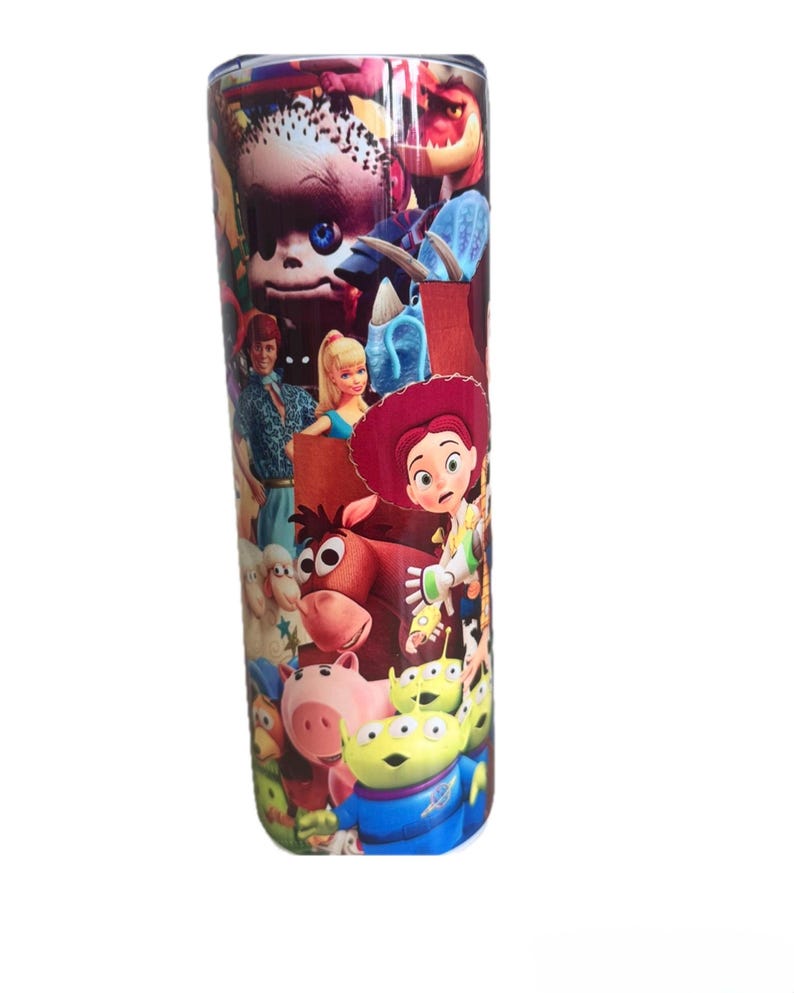 Puede incluir: Un vaso cil&iacute;ndrico de acero inoxidable con un estampado colorido que rodea todo el recipiente, mostrando varios personajes animados, incluyendo una vaquera de pelo rojo, un caballo marr&oacute;n, un cerdo rosa y alien&iacute;genas verdes de tres ojos.