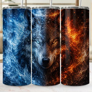 May include: A cylindrical tumbler featuring a split design of a wolf. The left side displays a blue icy theme with snowflakes and jagged crystals, while the right side shows a fiery orange and red flame pattern. A metal straw is inserted at the top.