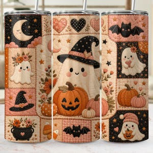 May include: A cylindrical tumbler featuring a quilted-style pattern with Halloween motifs including ghosts, pumpkins, bats, moons, hearts, and witch hats in a colour palette of orange, black, cream, and soft pink. The design includes a metal straw.