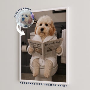 May include: A framed print featuring a light-coloured dog wearing a white bathrobe, sitting on a toilet and reading a newspaper titled The Daily Tail with the headline Hugo Voted Cutest Pup. A circular inset shows a pet photo with the text Your Pet Photo.