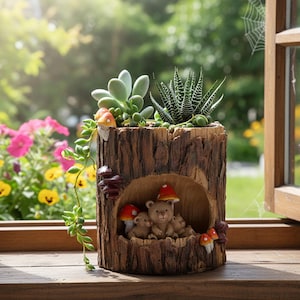 May include: A brown tree stump planter featuring a hollow cavity containing three small bear figurines and red-capped mushrooms. The top holds a green succulent and a spiky Haworthia plant, with a trailing vine of green beads cascading down the side.