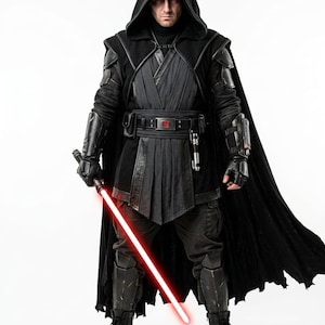 Peut inclure: Un costume noir à capuche comprenant une tunique superposée, une large ceinture avec un emblème rouge, des gantelets blindés sombres et des protège-tibias. La tenue inclut une longue cape fluide et des bottes noires, avec un sabre laser rouge.