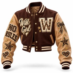 May include: A brown and tan varsity jacket featuring cream-coloured striped ribbed cuffs and collar. The front displays the text Wild Girl and a large letter W with leopard print. The sleeves are adorned with leopard print patches of stars, hearts, a bow, and the text NO RULES.