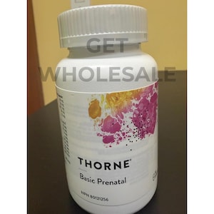 Könnte beinhalten: Eine weiße Kunststoffflasche mit geriffeltem Verschluss, die Thorne Basic Prenatal Nahrungsergänzungsmittel enthält. Das Etikett zeigt den Text GET WHOLESALE, THORNE Basic Prenatal und NPN 80121256 sowie eine abstrakte Grafik mit gelben und rosa Farbtupfern.