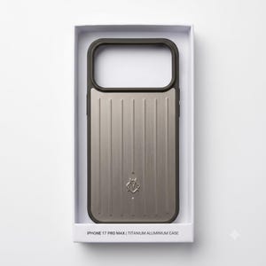 May include: A rectangular phone case for an iPhone 17 Pro Max in a white box. The case features a brushed metallic silver back with vertical grooves and a dark gray frame. A small silver logo is centered near the bottom. Text reads IPHONE 17 PRO MAX | TITANIUM ALUMINIUM CASE.