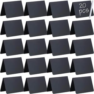 May include: A set of 20 black rectangular chalkboard signs, each folded into a tent shape for standing. The top right sign features the white text 20 pcs, and a single white chalk stick is positioned vertically next to it for writing.