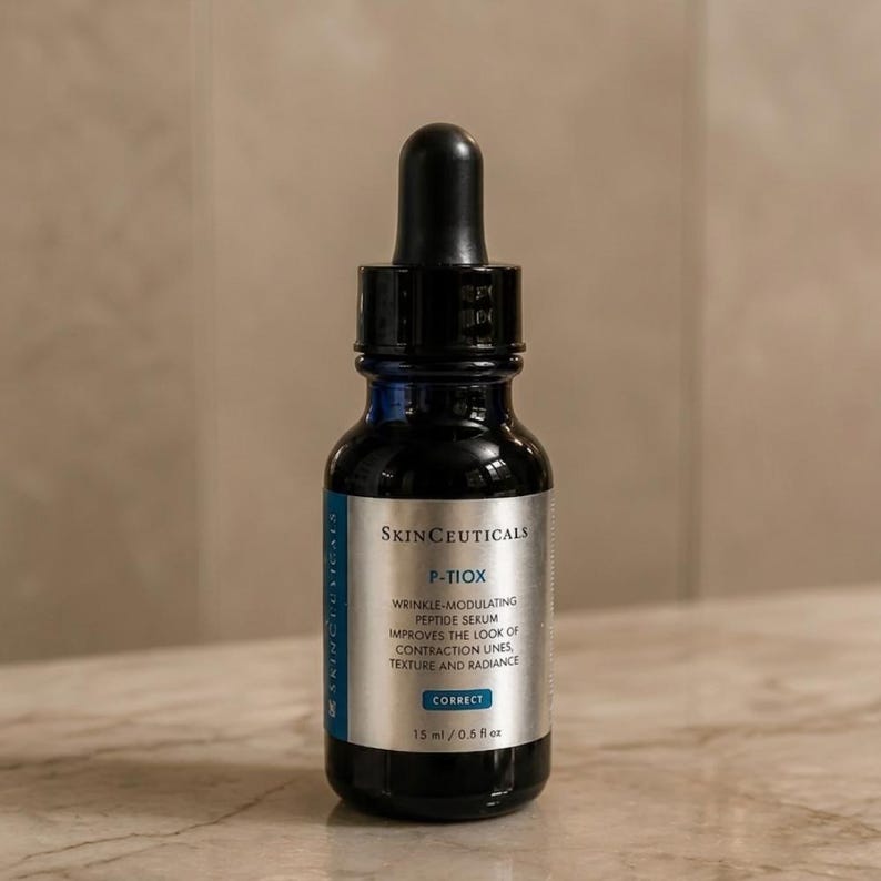May include: A dark blue glass dropper bottle of SkinCeuticals P-TIOX wrinkle-modulating peptide serum. The silver label features black text, a blue accent bar with the word CORRECT, and clearly displays the volume as 15 ml / 0.5 fl oz.