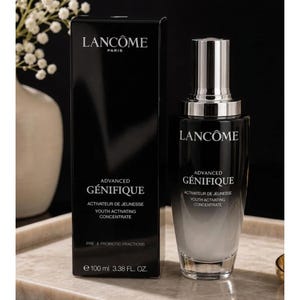 May include: A black Lanc&ocirc;me Advanced G&eacute;nifique Youth Activating Concentrate bottle and its matching rectangular box. The bottle features a silver cap and a black-to-clear gradient glass body. The text reads Lanc&ocirc;me Paris, Advanced G&eacute;nifique, Activateur de Jeunesse, Youth Activating Concentrate, and Pre- & Probiotic Fractions, with 100 ml 3.38 fl. oz. printed on the box.