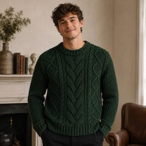 Puede incluir: Un suéter de manga larga en color verde bosque oscuro que presenta un patrón de tejido de cable grueso con un diseño de trenza vertical central, un cuello redondo acanalado y puños acanalados. El suéter está hecho de tejido grueso y texturizado.